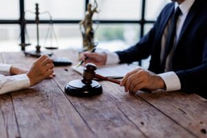 An injury victim sitting with a lawyer. An attorney can help you get help if you were injured in the Nippon Dynawave packaging mill explosion.